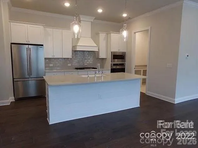 a kitchen with granite countertop a sink a stove and cabinets