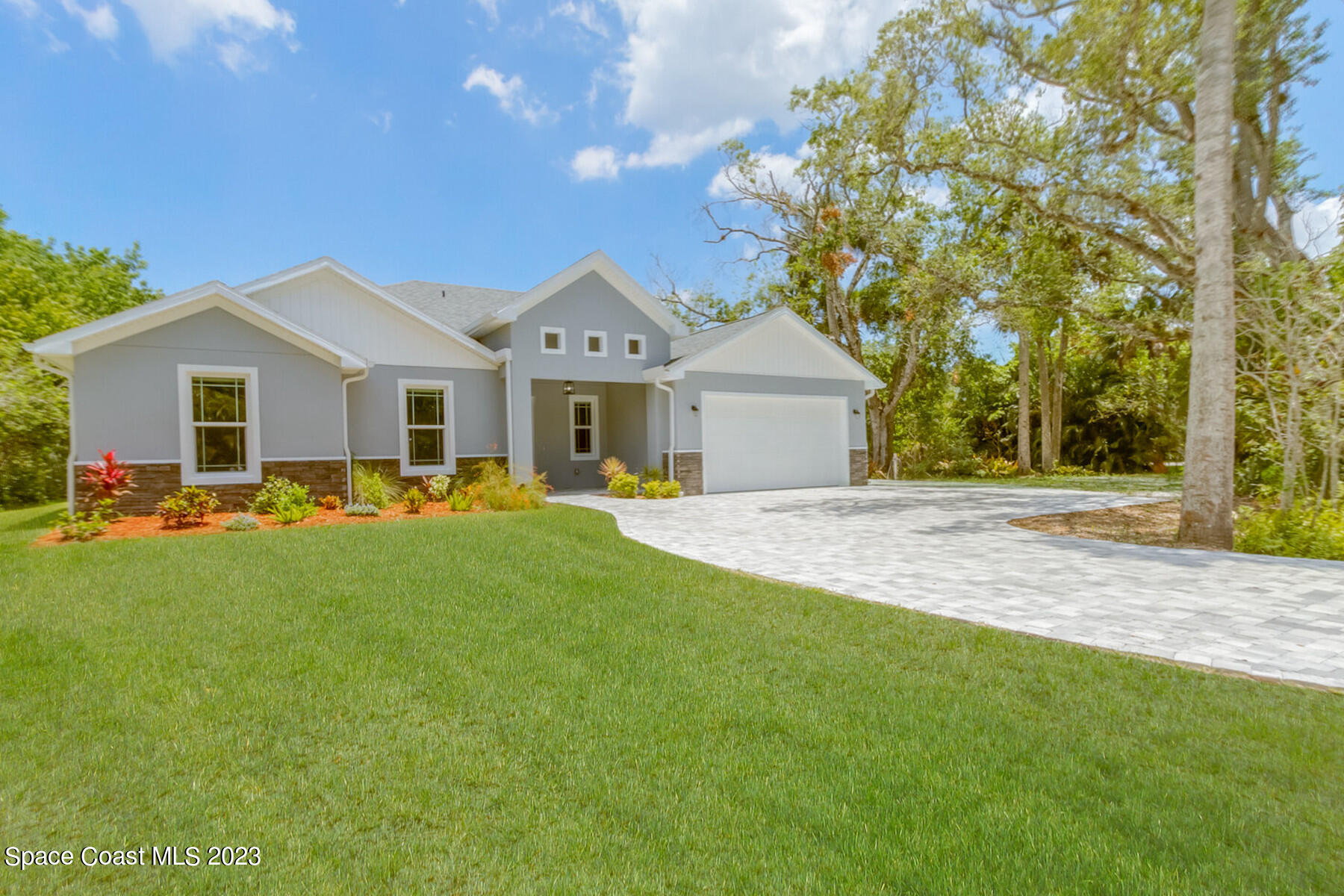 a front view of a house with a garden and yard