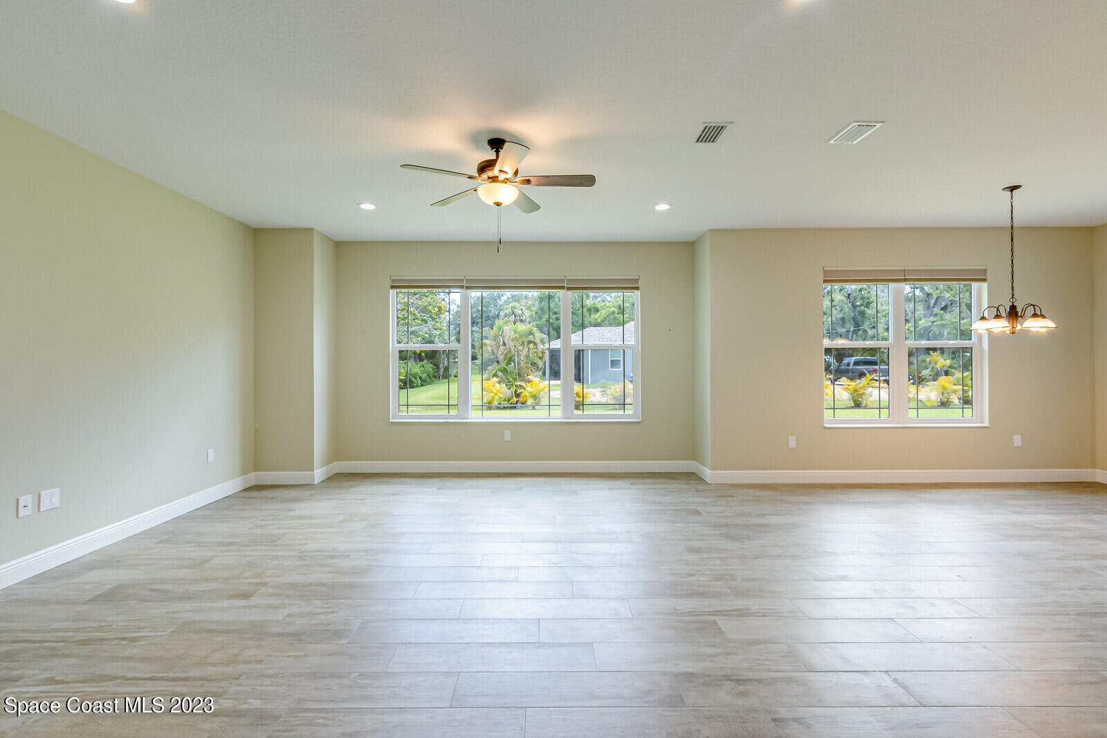 618 Hammock Road Melbourne, FL 32904 - Photo 17 of 59 an empty room with wooden floor chandelier and windows