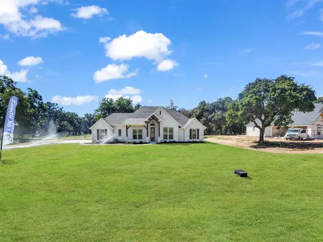 a front view of a house with a yard and trees