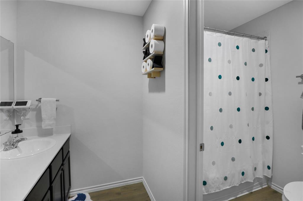 6538 Diver Street Princeton, TX 75407 - Photo 23 of 31 Bathroom featuring dark wood-style flooring, vanity, and shower / tub combo