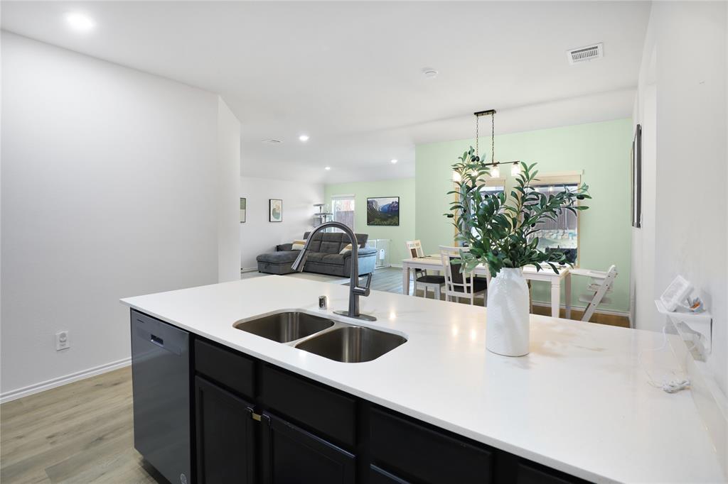 6538 Diver Street Princeton, TX 75407 - Photo 8 of 31 Kitchen with dark cabinetry, light wood-style flooring, dishwashing machine, decorative light fixtures, and recessed lighting