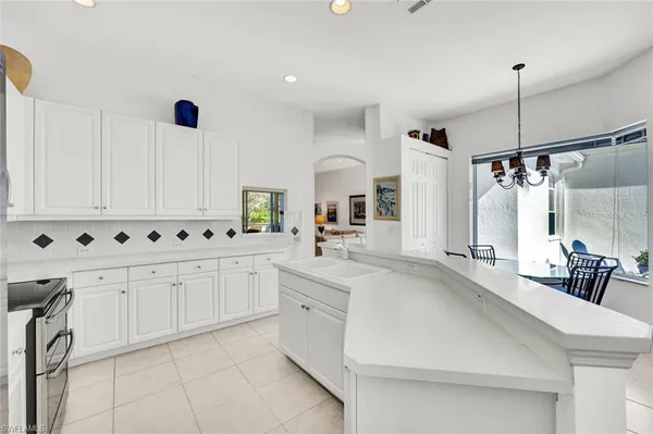 a large white kitchen with a sink and cabinets