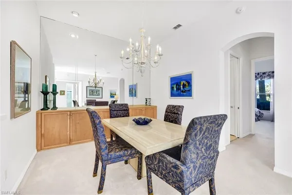 a dining room with furniture a chandelier and window