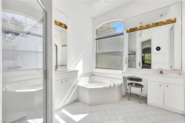 a bathroom with a tub sink and mirror