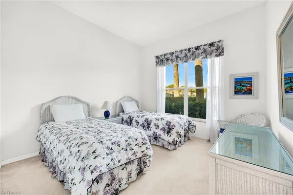 a bedroom with two beds and large window