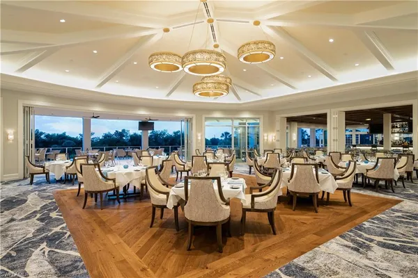 a dining room with lots of tables a large window and chairs