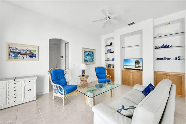 a living room with furniture a rug and white walls