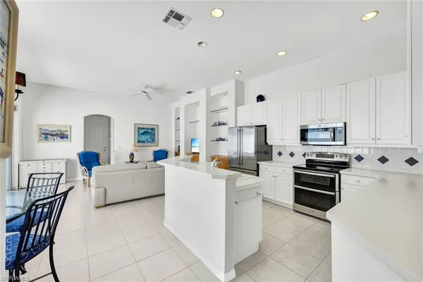 a large white kitchen with stainless steel appliances