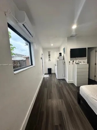a view of a hallway with wooden floor windows and a fireplace