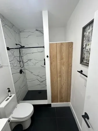 a bathroom with a toilet and a shower