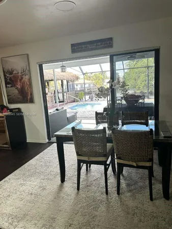 a dining room with furniture and a floor to ceiling window