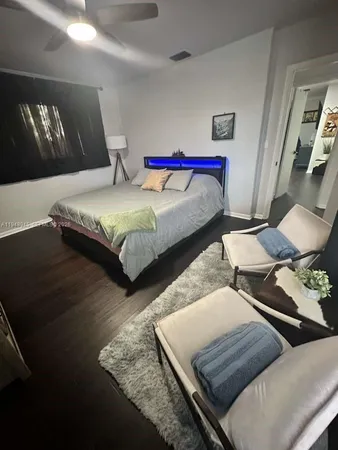 a bedroom with bed and a night stand with wooden floor