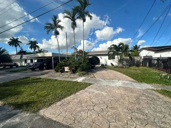 a view of a yard with plants and a fountain