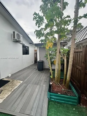 a view of house with backyard and a tree