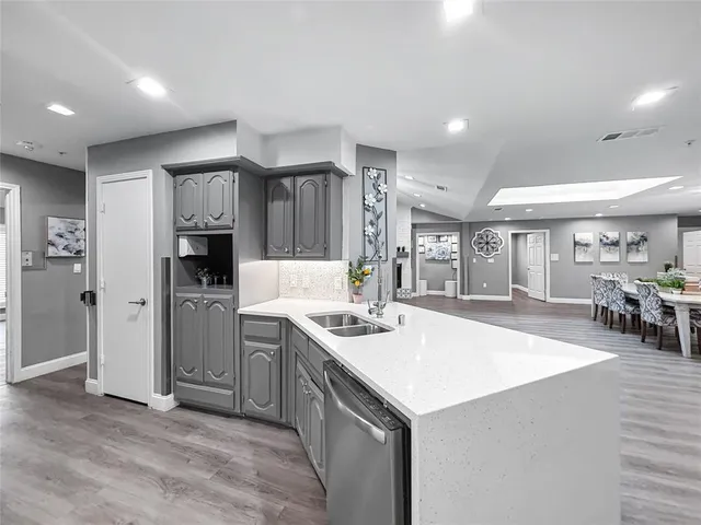 a kitchen with a sink a stove cabinets and wooden floor
