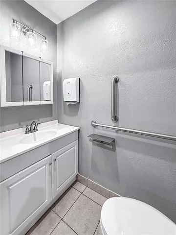 a bathroom with a sink a toilet and mirror