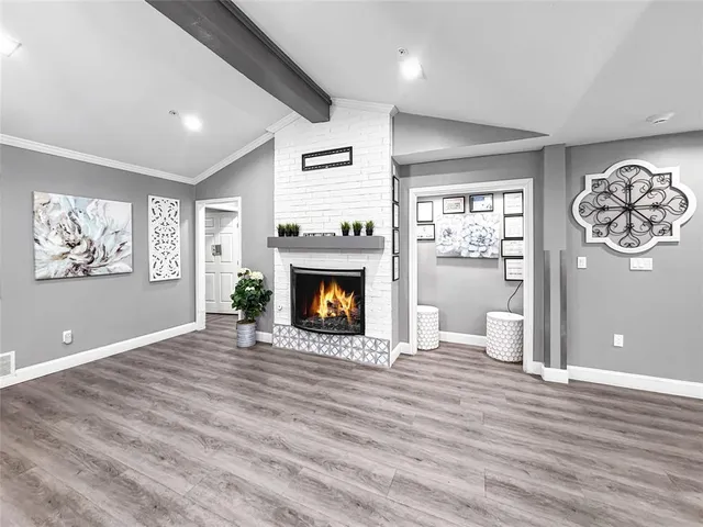 a view of an empty room with a window and fireplace