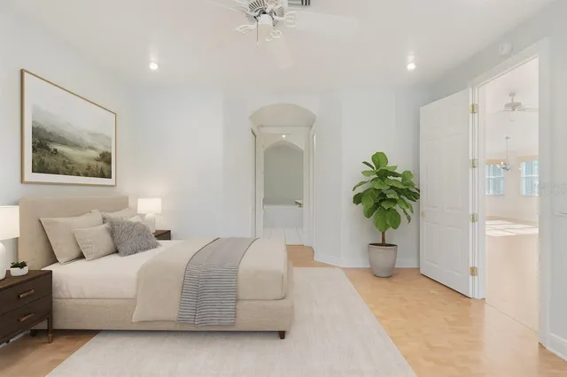 a bedroom with a large bed and a potted plant