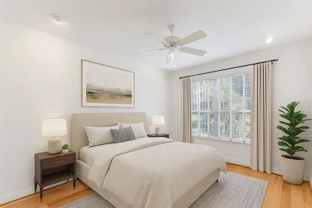 a bedroom with a large bed and a potted plant