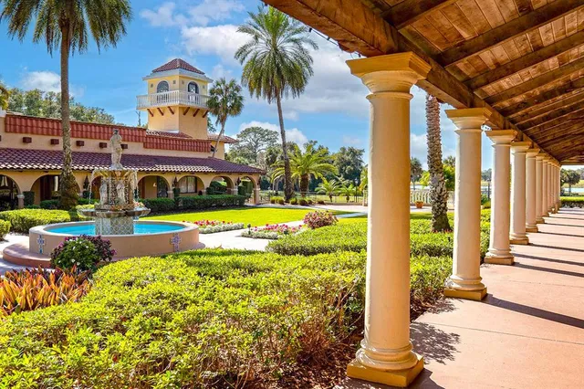 a view of swimming pool with lawn chairs and plants