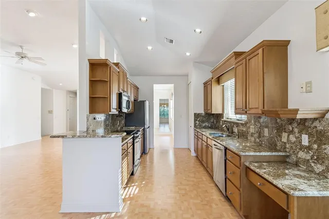 a kitchen with stainless steel appliances granite countertop a sink stove and refrigerator