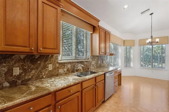 a kitchen with stainless steel appliances granite countertop a sink a counter space and cabinets