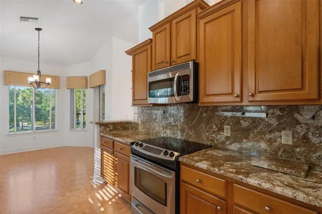 a kitchen with granite countertop a stove a sink and a microwave