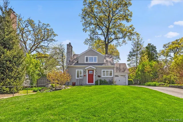 a view of a house with a big yard and large trees