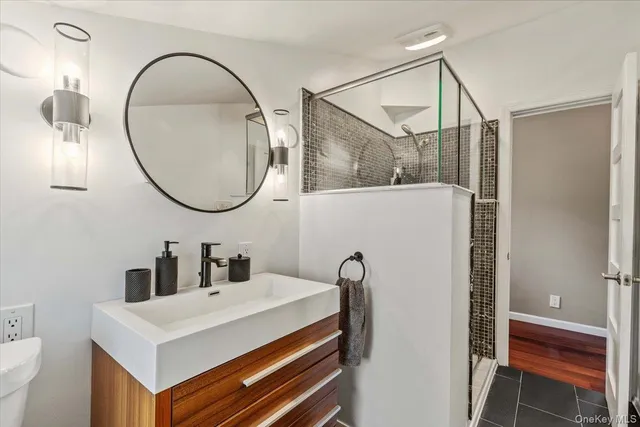 a bathroom with a sink a toilet and a mirror
