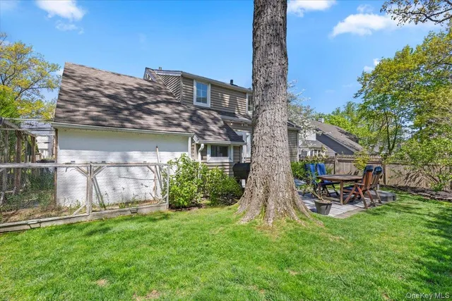 a view of a chair and table in backyard of the house