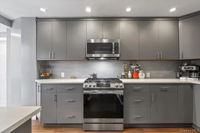 a kitchen with stainless steel appliances granite countertop a stove a sink and a microwave