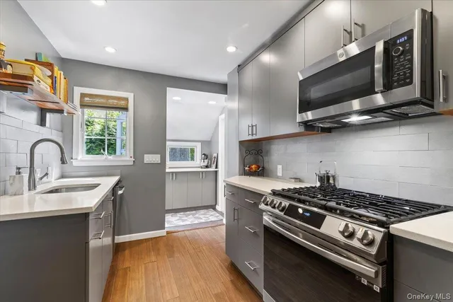 a kitchen with stainless steel appliances a sink a stove and cabinets