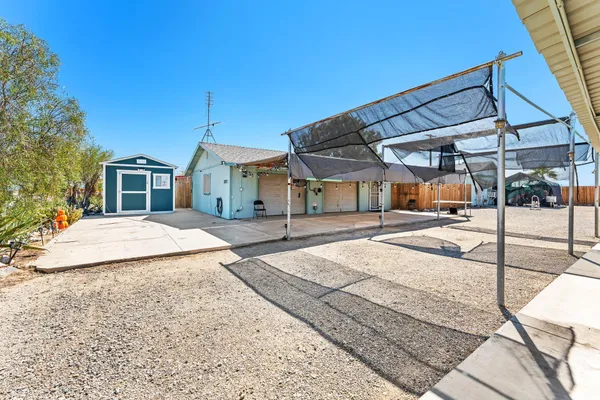 a view of a house with backyard and sitting area