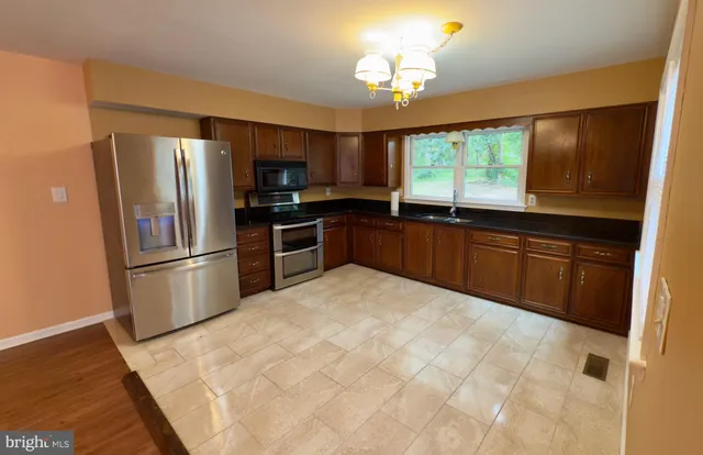 a kitchen with stainless steel appliances granite countertop a stove refrigerator and microwave