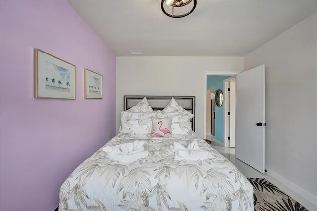 a large bed sitting in a bedroom next to a window