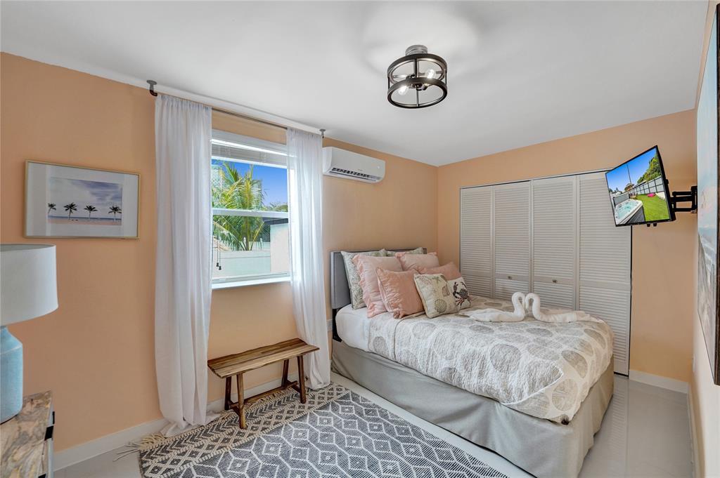 8236 Northwest 1st Place, Unit 2 Miami, FL 33150 - Photo 9 of 21 a bedroom with a bed and a chandelier