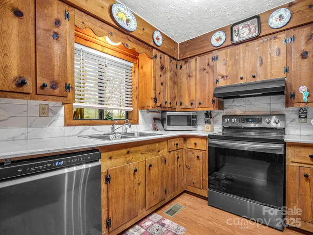 a kitchen with stainless steel appliances a stove and a sink