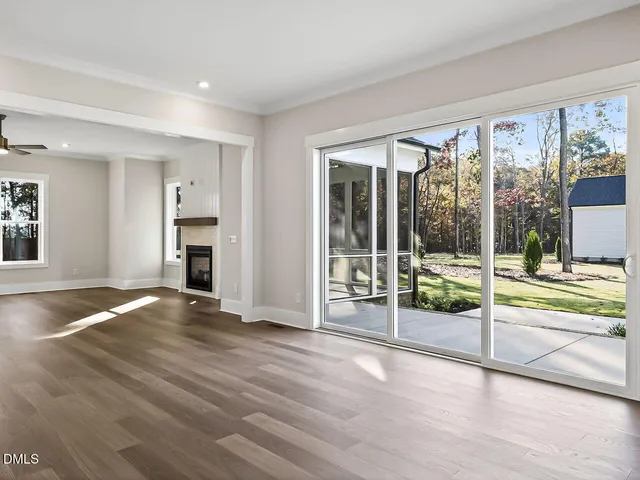 a view of empty room with wooden floor and floor to ceiling window