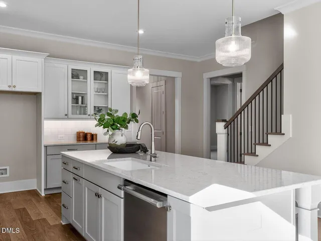 a kitchen with stainless steel appliances kitchen island granite countertop a sink a stove and a wooden floors