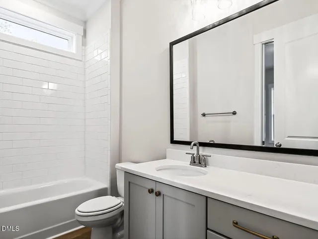a bathroom with a granite countertop sink a toilet and shower