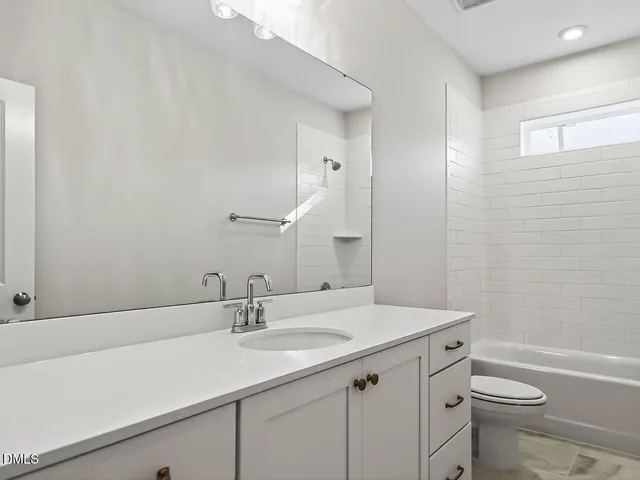 a bathroom with a sink a toilet a shower and a mirror