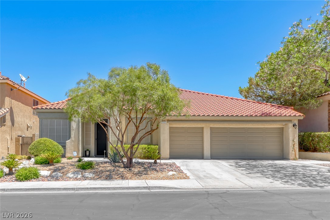 2122 Mooreview Street Henderson, NV 89012 - Photo 1 of 44 Well-maintained desert landscaping frames this charming facade, boasting a classic tile roof and a spacious attached garage.