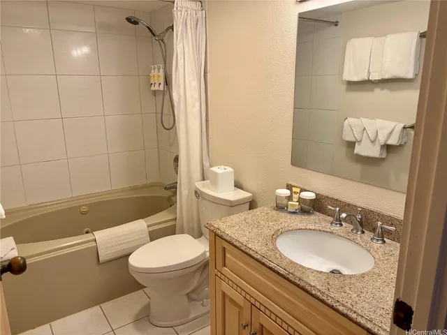 a bathroom with a granite countertop toilet sink and mirror