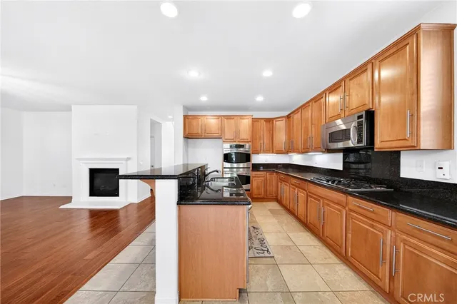 a kitchen with granite countertop a refrigerator sink and cabinets