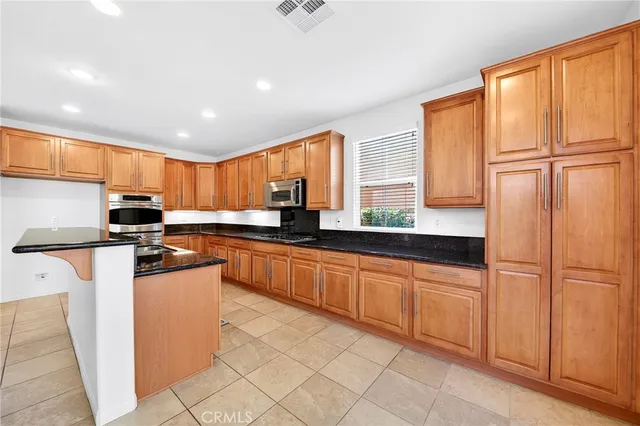 a kitchen with stainless steel appliances granite countertop a stove a sink and a refrigerator