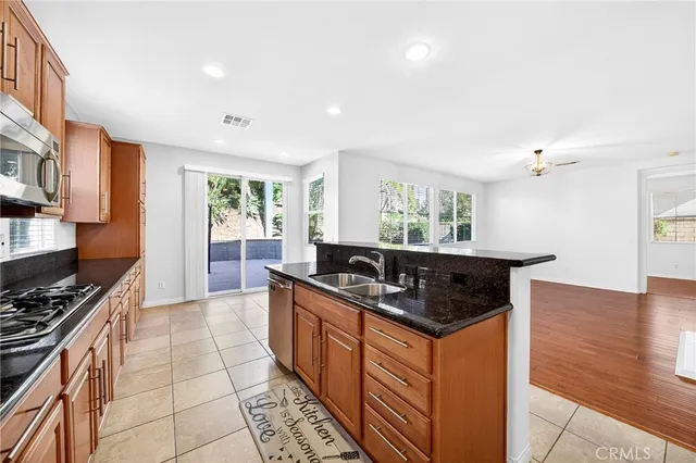 a view of a kitchen with a sink wooden cabinets and a window