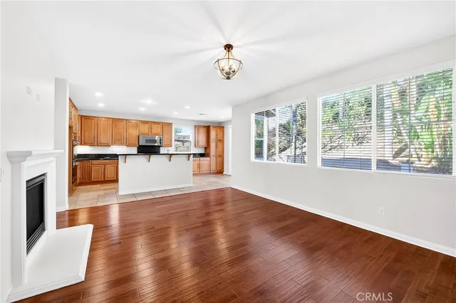 a view of a big room with wooden floor and a kitchen