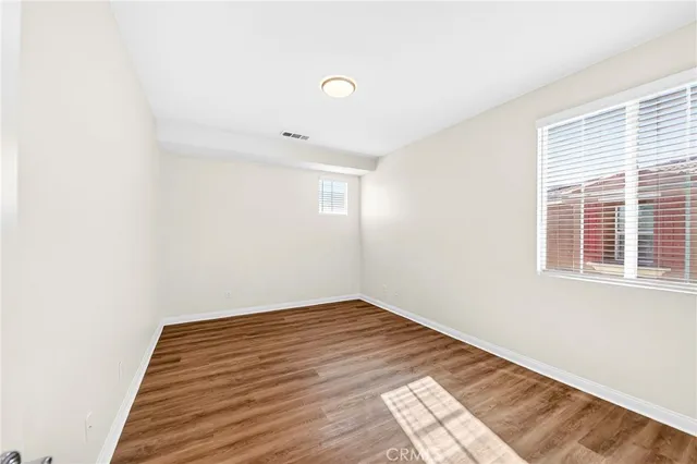 a view of a room with wooden floor and white walls
