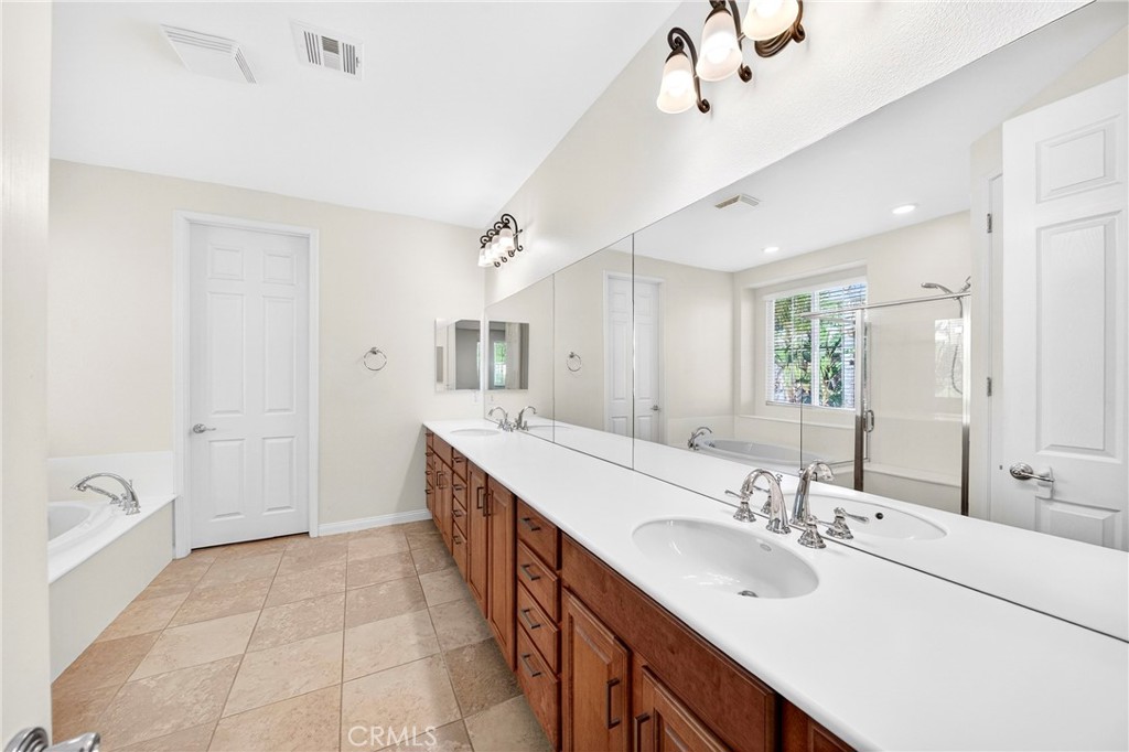 13740 Santa Maria Drive Rancho Cucamonga, CA 91739 - Photo 34 of 53 a spacious bathroom with a double vanity sink mirror double and shower